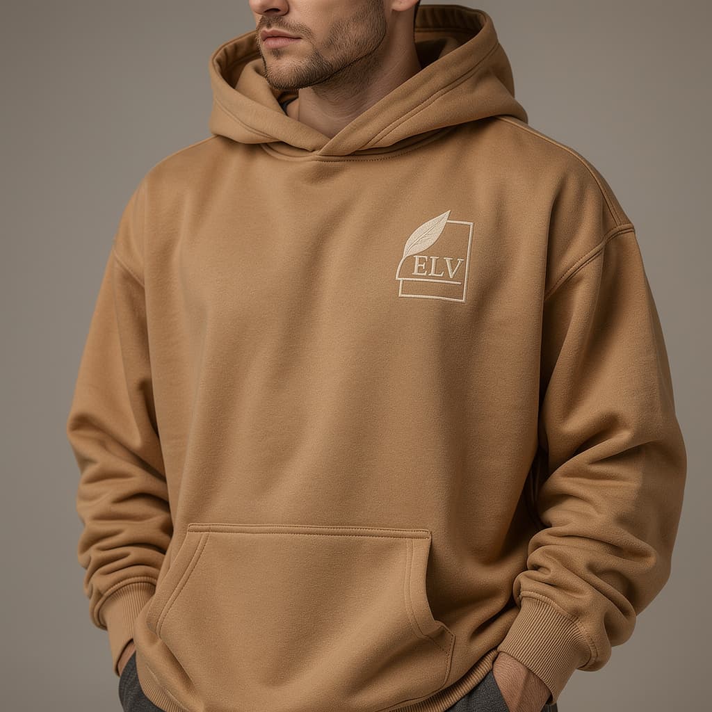 Person wearing a brown hoodie with a logo on a gray background