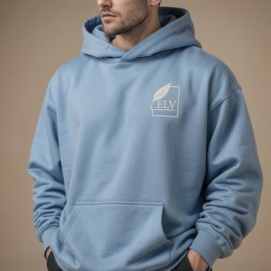 Person wearing a light blue hoodie with a logo on a beige background